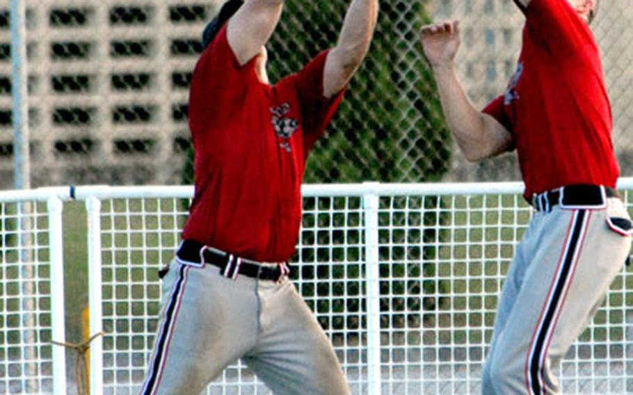 Outfielders Brian Denman and Jonathan Cape of Club Red converge on a fly ball during Saturday&#39;s knockout game in the 10th Firecracker Shootout Interservice Softball Tournament. Cape, right, made the catch. Club Red eliminated Yellow Box 10-6 in an all-Okinawa battle. See more results in the Far East interservice scoreboard.