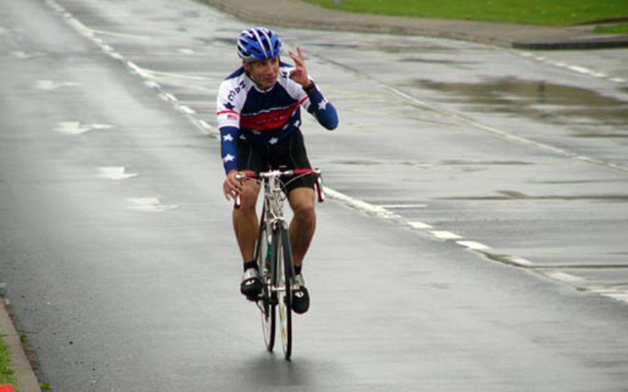 Women’s road race winner Jessiannna Osborne of Spangdahlem flashes the victory sign through the rain on Sunday after covering 30.9 kilometers in one hour, five minutes, 32 seconds at Spangdahlem Air Base, Germany.