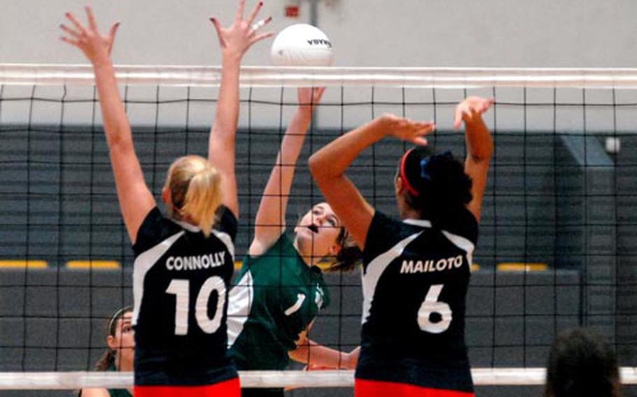 Bridie Condon of Naples knocks the ball over the net between the outstretched hands of Aviano&#39;s Kelly Connolly and Jasmine Mailoto. Naples won the Division II match 25-20, 14-25, 15-10 at Ramstein on Friday.