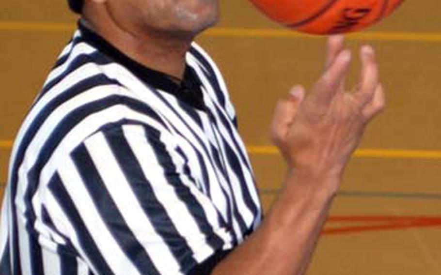 Longtime United Services For Japan Officials Association basketball referee Paul Stearns balances a basketball on his finger during a timeout during Saturday&#39;s series of six high school basketball games at Capps Gym, Yokota High School.