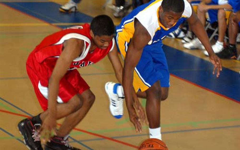 Kenneth Dixon, left, of the E.J. King Cobras and Keron Brown of the Yokota Panthers chase a loose ball.