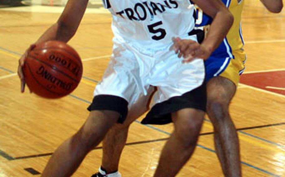 Zama American’s Adonis Jackson, left, tries to dribble around Yokota’s Antony Phillips during Wednesday’s game at Camp Zama, Japan. Yokota won 49-45.