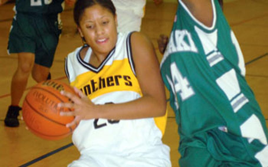 Kadena junior point guard Britney Wise, left, has her path to the basket blocked by Kubasaki junior guard Bri Davis during Tuesday’s Okinawa Activities Council girls basketball game at Kadena High School, Kadena Air Base, Okinawa.