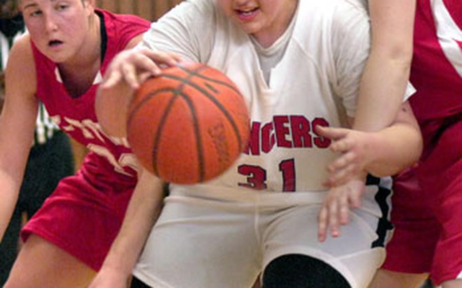 Lisa McBride of Lakenheath High School moves the ball past Barbara Burriss and Karah Helm of Kaiserslautern during their D1 Match-up Saturday at Vogelweh. Lakenheath defeated Kaiserslautern 46-41 in overtime.