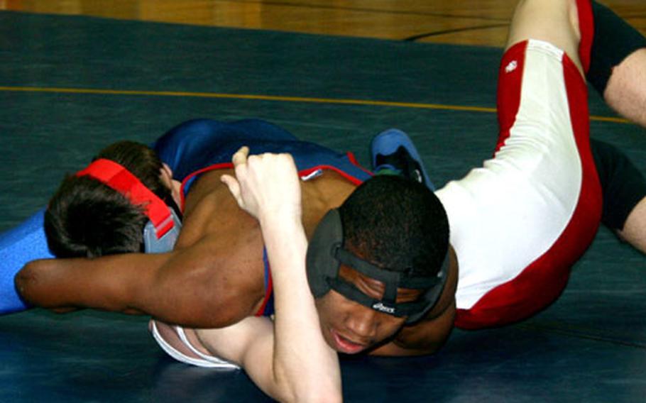 Freshman Marshall Smith of Ramstein, top, scores back points on Peter Phillips of Kaiserlautern on his way to a 12-6 win. The win helped boost host Ramstein to the top team score — the team&#39;s fourth meet victory to go with a second-place finish.
