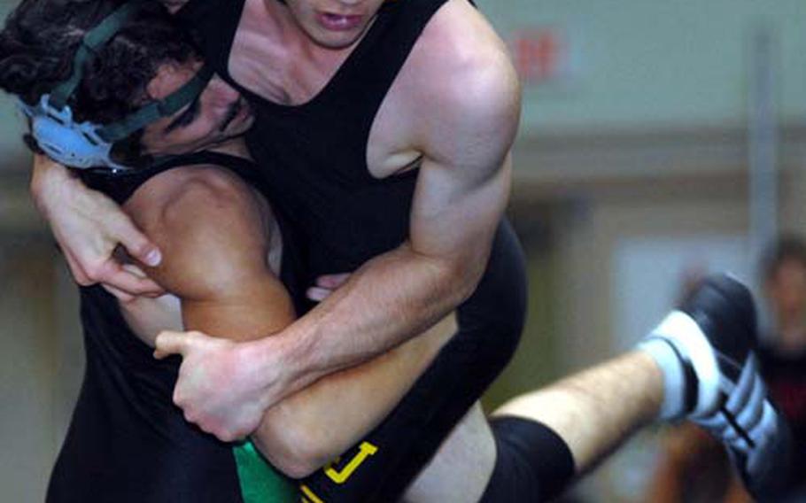 Kubasaki’s Josh Bales, left, lifts Yuki Riches of American School In Japan into the air during Friday’s 129-pound bout in the dual-meet portion of the 2nd Rumble on the Rock Wrestling Tournament at Camp Foster, Okinawa. Riches decisioned Bales 2-0 (3-1, 4-1) and Bales’ left shoulder was injured during the bout. But defending champion Kubasaki won the dual meet 34-18 and went on to claim second place in the four-way round-robin tournament.