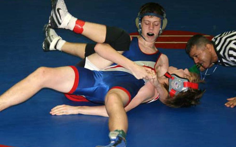 Dylan Trautman of Ramstein applies a Peterson pinning combination on Matt Harvey of Kaiserslautern during the ir 140-pound bout in Western Sectional wrestling tournament at Ramstein on Saturday. The top two finishers from each of Saturday&#39;s four sectionals plus four wild card wrestlers qualify for the DODDS-Europe championship this coming Friday and Saturday.