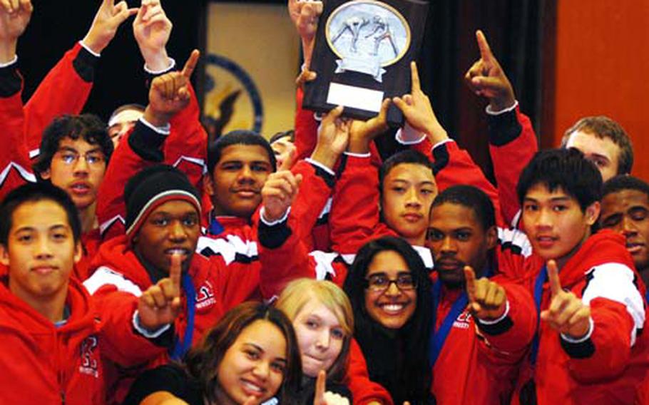 Nile C. Kinnick wrestlers and supporters celebrate with the trophy after the Red Devils clinched the Kanto Plain Association of Secondary Schools Tournament championship at St. Mary’s International School in Tokyo. It’s Kinnick’s first Kanto title in five years. The Red Devils won three individual gold medals and outdistanced host St. Mary’s 77-68 in the team standings. Last year’s champion Yokota finished third with 61 points.