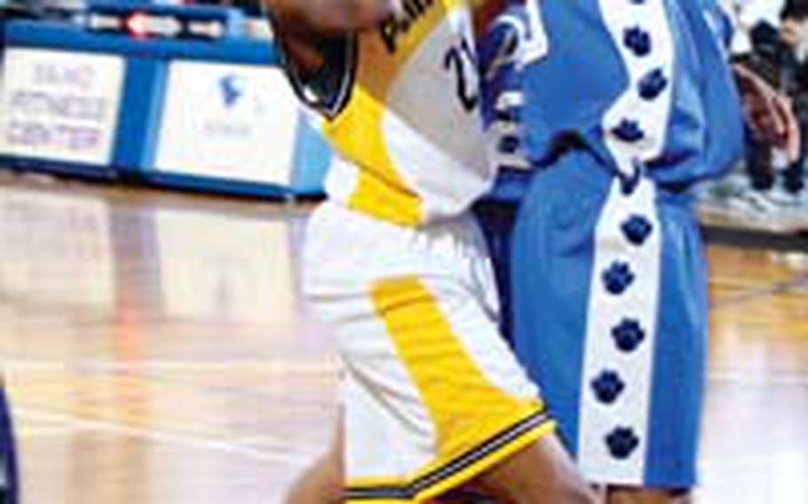 Kadena’s Jasmine Taylor has her shot blocked by Anya Brown of Yokota during Tuesday’s Class AA pool-play game at Camp Zama, Japan, but Kadena beat Yokota 66-33 behind Taylor’s 15 blocks. Kadena earned a No. 1 seed entering the single-elimination playoffs.