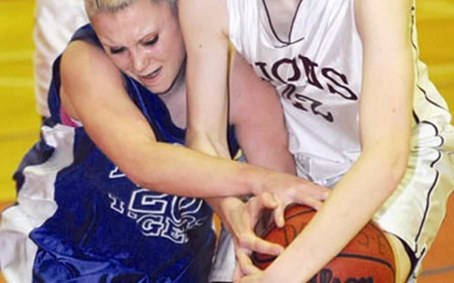 Mandy LaVanway of Hohenfels, left, and AFNORTH’s Natalie Everingham fight for a loose ball in opening-day action for Division III in the DODDS-Europe basketball finals in Mannheim, Germany, on Thursday. AFNORTH beat Hohenfels 37-23.
