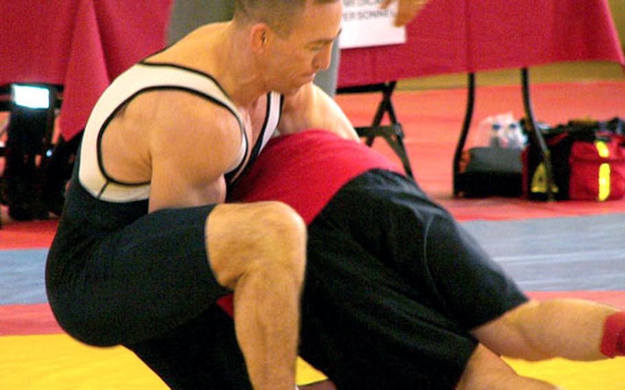 Working from the top in a referee’s-position restart, Steve Horton of Ramstein lifts Seth Williams en route to throwing the Bamberg-based wrestler for a five-point move Saturday in a 163-pound bout. Horton won the match by winning the first two of three scheduled rounds.