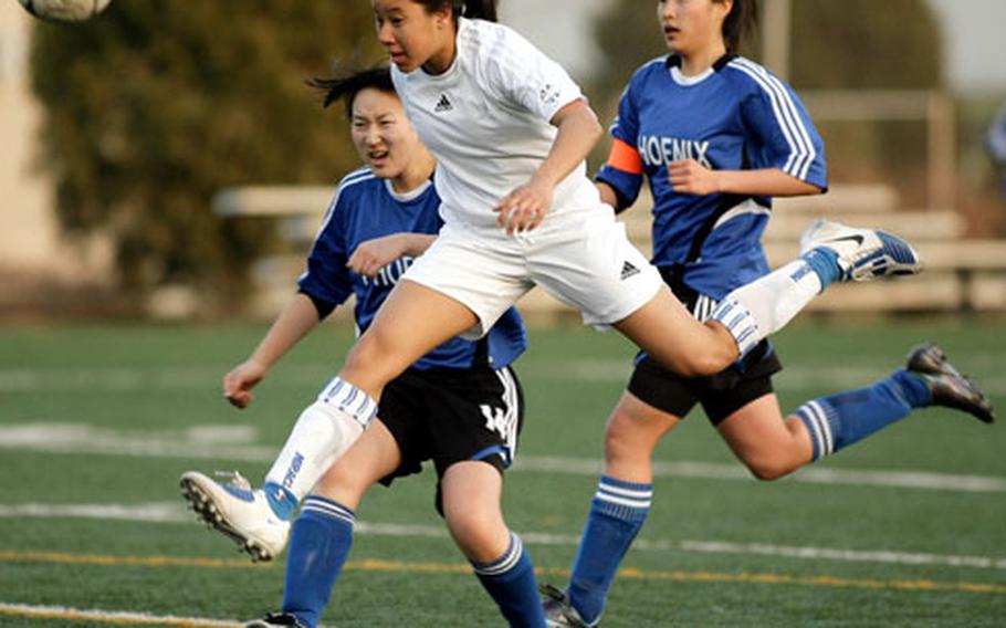 In one of the handful of times she hasn’t played goalkeeper, Seoul American sophomore Liz Gleaves heads the ball past Korea International’s Michelle Lim, left, and Mina Park during a Korean-American Interscholastic Activities Conference girls soccer match at South Post, Yongsan Garrison, South Korea. The Falcons won 4-0.