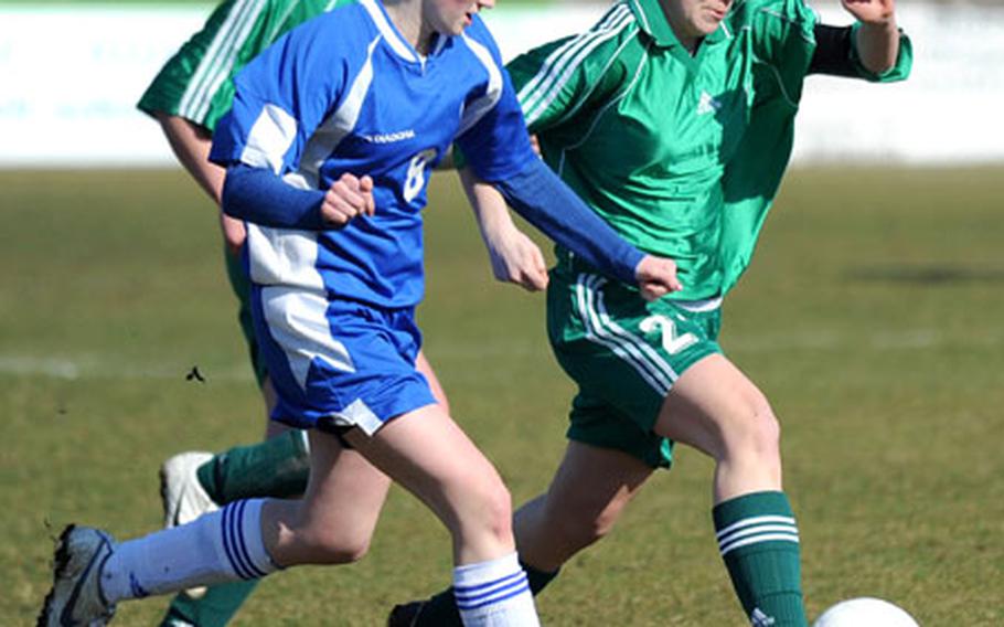 SHAPE&#39;s Brittany Brown, right, takes the ball upfield against Wiesbaden&#39;s Emma Curtsinger.