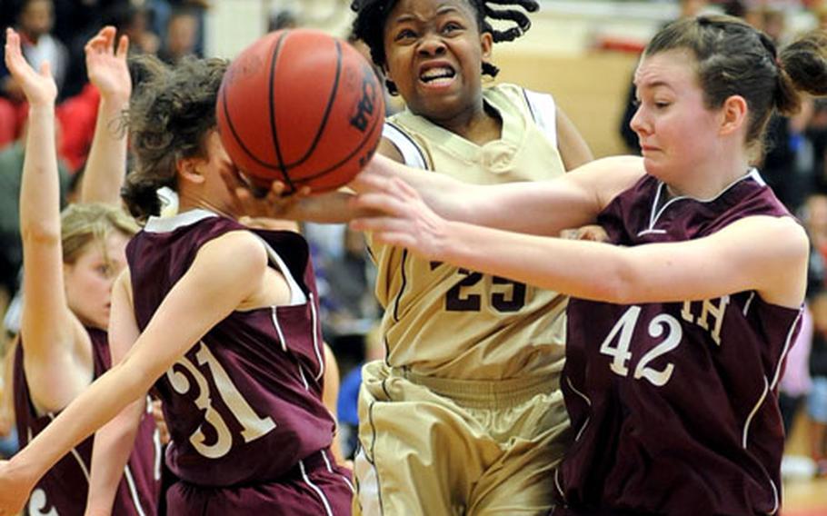 Baumholder&#39;s Veronne Clark attempts an underhand layup between AFNORTH&#39;s Brenda Broadwater, left, and Natalie Everingham in the girls Division III final of the DODDS-Europe basketball tournament in Mannheim in February. Clark was named to the All-Europe first team for the second-straight season, while Broadwater made the second team.