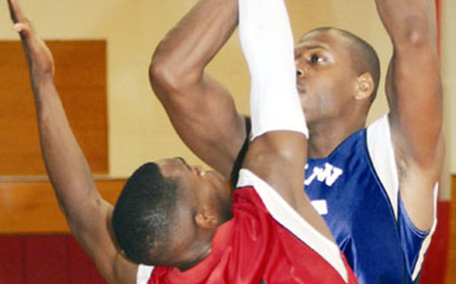 Jelani Nix, right, of 1st Marine Aircraft Wing has his shot blocked by Shun Haskins of Marine Corps Base Camp S.D. Butler during Saturday’s championship game in the Marine Corps Far East Regional Basketball Tournament at Camp Kinser, Okinawa. Nix had 21 points, 22 rebounds, seven assists, five steals and three blocked shots as Wing won its third straight title by beating Base 90-72.