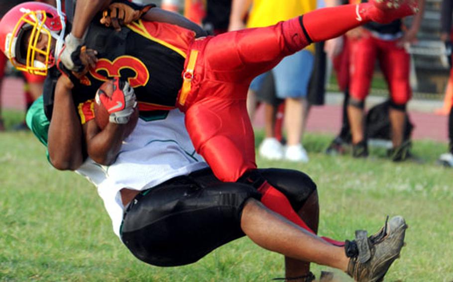 Foster Bulldogs running back Dyamon Durant is slammed to the ground by Perry Davis of the Kadena Dragons during Saturday&#39;s game. Foster beat Kadena 23-20, clinching the Southern Division title and a first-round playoff bye.