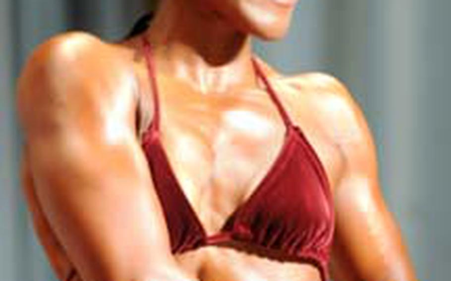 Women&#39;s middleweight and overall champion Star Kirkwood performs a side chest pose.