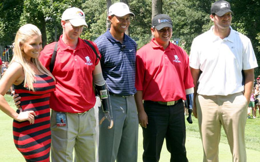 Maj. Ken Dwyer (second from left) and Staff Sgt. Ramon Padilla (second from right), wounded warriors from Walter Reed Army Medical Center, hit the ceremonial first shot with Tiger Woods, center, to kick off the AT&T National on Wednesday. Jessica Simpson, left, sang the national anthem. Dallas Cowboys quarterback Tony Romo, right, was Woods’ partner in the pro-am.