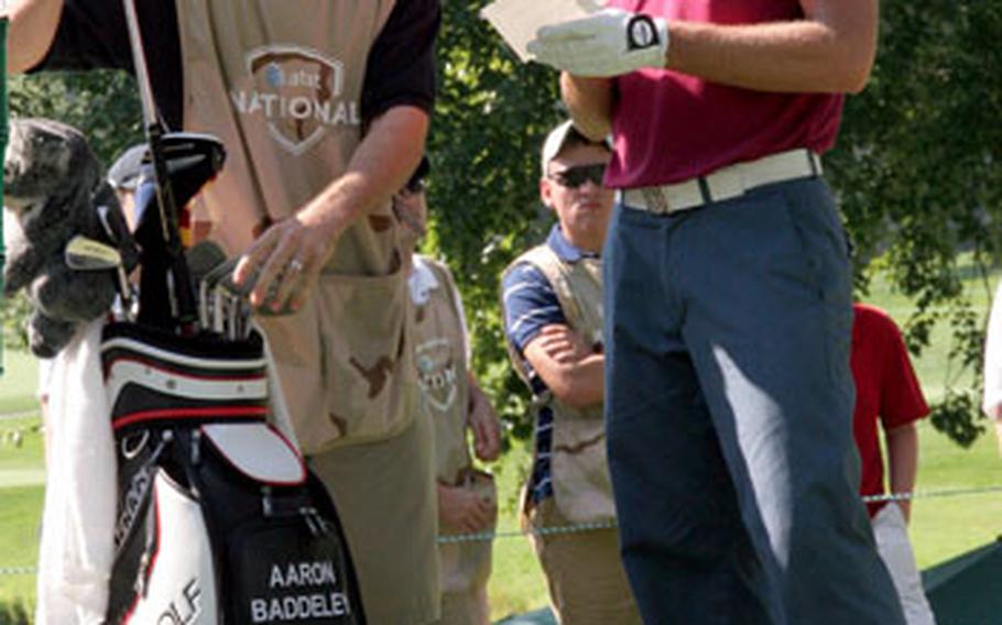 PGA golfer Aaron Baddeley gets his club from Petty Officer 2nd Class Austin Mosher, of Mt. Airy, Md. Mosher was picked from a pool of applicants to be a guest "military caddy" for the 7th hole, a par 3.