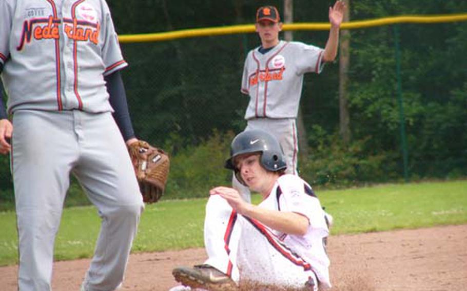 KMC’s Joey Beach slides into third on an uncontested steal Sunday during the home team’s 8-1 victory over the Netherlands in both teams’ opening game of the six-day European Senior League Regional tournament at Ramstein Air Base, Germany. Netherlands shortstop Wyenand Ruben signals his catcher not to throw to third baseman Jelle Voshoc.