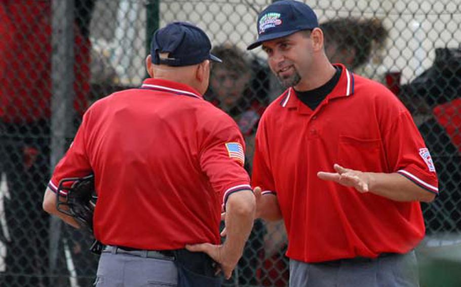 Umpires Jack Ruscoe, left, and Joey Broxmeyer talk between innings during a game at the Softball European Regionals between KMC and Georgia. The pair paid their own way from the U.S. to umpire the tournament.
