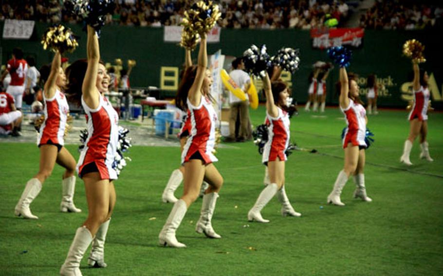 Japanese cheerleaders shake their pompoms and cheer on their national team.