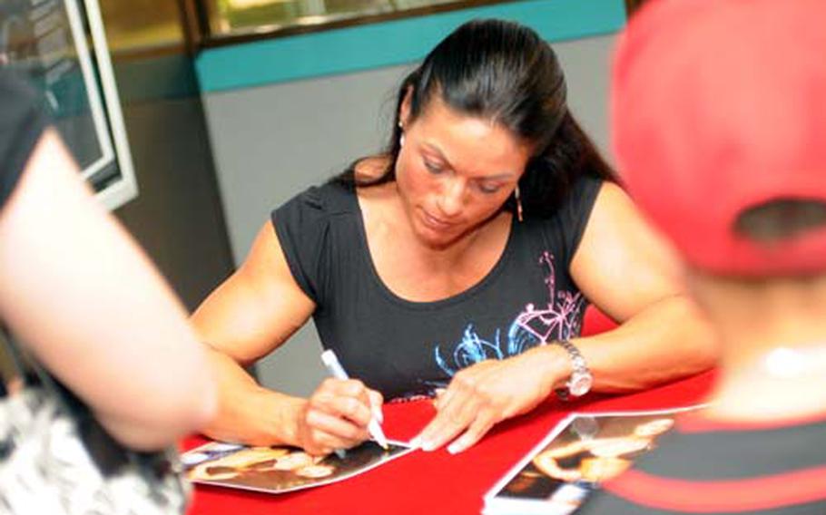 Troxell, Marine Corps gunnery sergeant, mom and professional bodybuilder, obliges autograph seekers as guest poser during Sunday’s 14th Far East Bodybuilding Championships at Camp Foster, Okinawa. “Time management is key,” she says about balancing bodybuilding with a military career and being a mom.