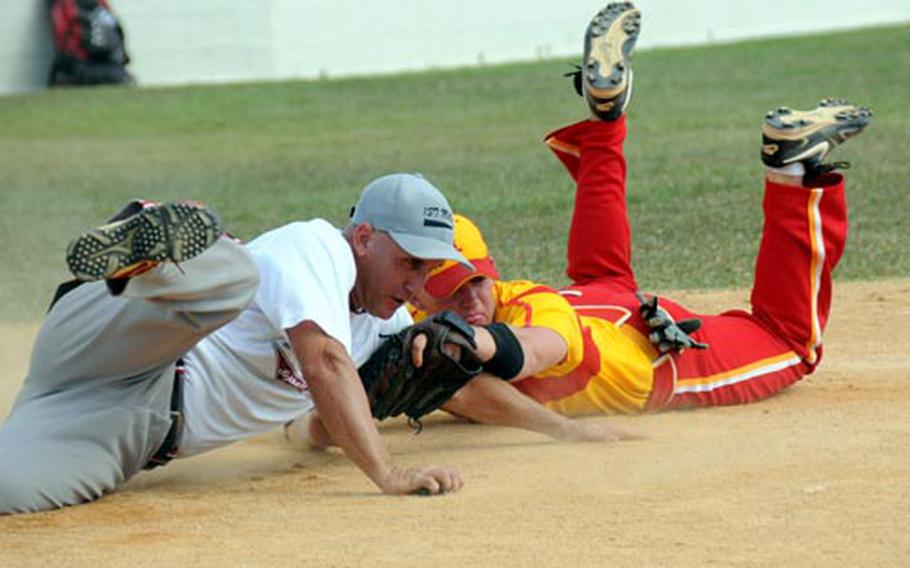 Doc Arbini of 1st Marine Aircraft Wing, Okinawa, left, is tagged out wide of home plate by catcher Ken Kohler of Marine Corps Air Station Iwakuni, Japan, during Friday’s winner’s bracket final in the Far East Regional Softball Tournament at Camp Foster, Okinawa. Wing beat Iwakuni 12-5 and again 5-3 in the evening championship game.
