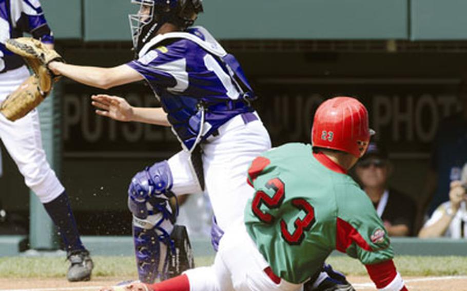 Mexico’s Raymundo Berrones slides under the tag of Kaiserslautern Military Community catcher Jacob Van Parys, scoring the first run Monday in the Little League World Series. KMC lost 13-0.