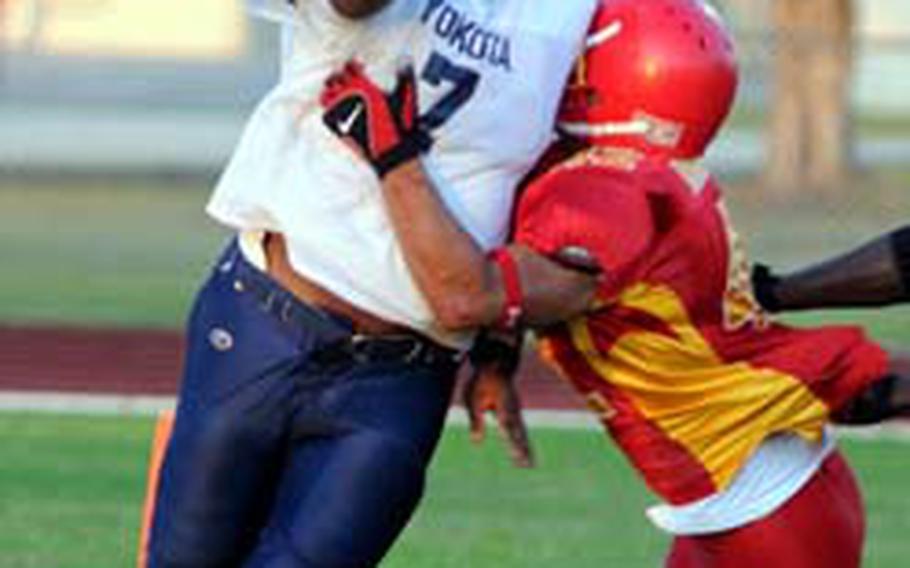 Yokota quarterback Ryan Jones (7) gets wrapped up by Foster defensive captain Tim Craig for a second-quarter safety during Saturday&#39;s U.S. Forces Japan-American Football League Torii Bowl championship game at Mike Petty Stadium, Kubasaki High School, Camp Foster, Okinawa. Foster won 30-6.