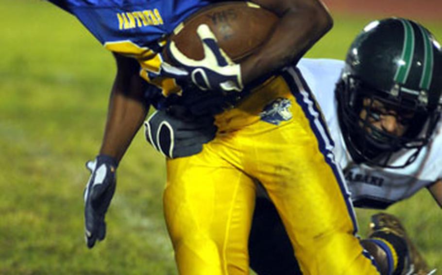 Yokota Panthers running back Gerald McCloud slips through the grasp of Kubasaki Dragons defender A.J. Watson during Saturday's game. The Panthers won 21-7.