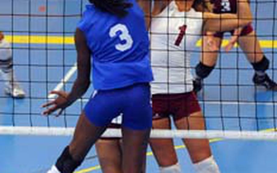 Vilseck's Sindi Beaulieu-Hains, hidden at left, and Anna Muzzy, right, try to block a shot by Ramstein's Nadia Booker in a DODDS-Europe volleyball match in Heidelberg on Saturday. Ramstein beat Vilseck 25-16, 25-18, 25-16.