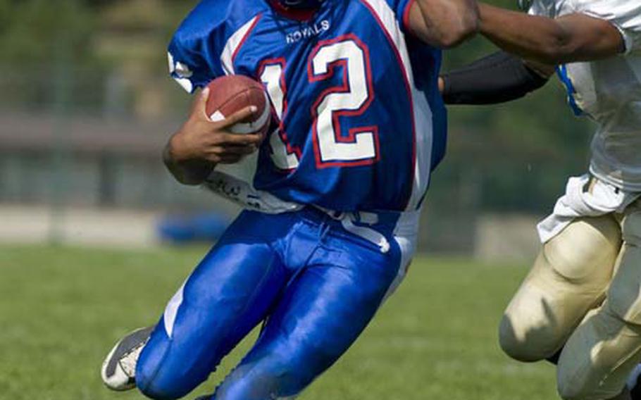 Ramstein senior quarterback Michael Wallace evades Wiesbaden defender Daniel Harris during the Royals’ 55-12 victory Saturday at Ramstein Air Base, Germany. The 6-foot-2, 200-pound Wallace had a hand in seven touchdowns: He ran for three, passed for three and caught a pass for the final one.