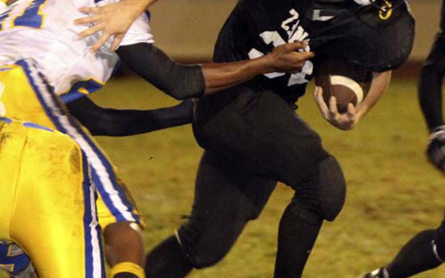 Zama American running back Michael Spencer plows through the tackle of the Yokota Panthers’ Wesly Cannonier during Friday’s DODEA Japan/Kanto Plain Association of Secondary Schools game at Camp Zama, Japan. Zama beat Yokota 33-6, its first on-field victory over the Panthers in 11 seasons.