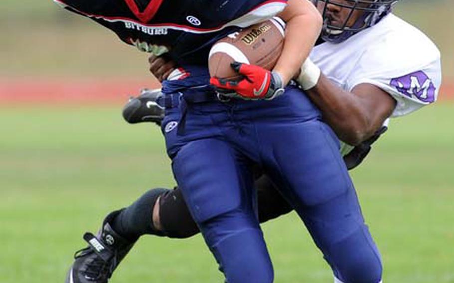 Mannheim&#39;s Trevin Hampton makes a leaping tackle to bring down Bitburg&#39;s Brandon Massie after Massie rushed for a big gain.
