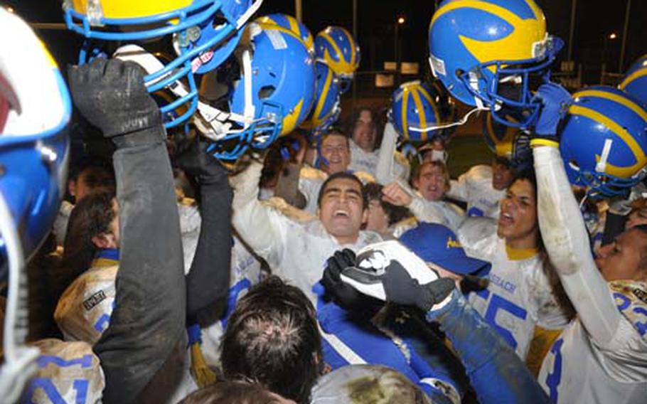 Ansbach Cougars quarterback Dominic Barrale, center, leads his team in celebration following a 48-6 victory over Bamberg on Friday night. It was the Cougars’ 29th consecutive triumph, a DODDS record.