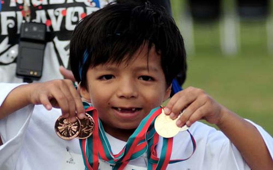 Akihiro Tokeshi holds up some the medals he earned Saturday during the 10th Anniversary Special Olympics at Kedana Air Base, Okinawa. About 900 special-needs athletes converged at Risner Sports Complex to compete, and about 300 special-needs artists displayed artwork. Officials said about 6,000 people showed up to support participants.