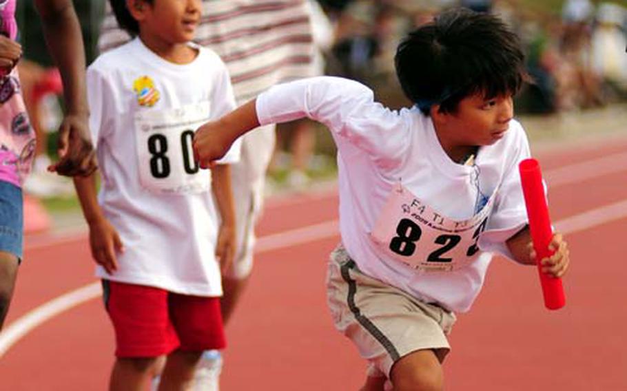 Eight-year-old Akihiro Tokeshi grabs his baton and heads around to last curve in the 4 by 100-meter relay race during the Special Olympics at the Risner Sports Complex on Kadena Air Base, Okinawa, on Saturday.