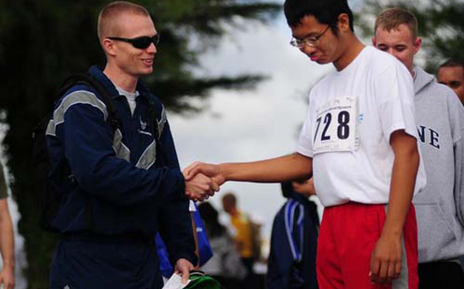 Air Force Staff Sgt. Daniel Van Stone encourages Kouichi Higa just before the standing long jump at the 10th Annual Special Olympics at Kadena Air Base on Saturday. Participants had to jump as far as they could from a standing position.