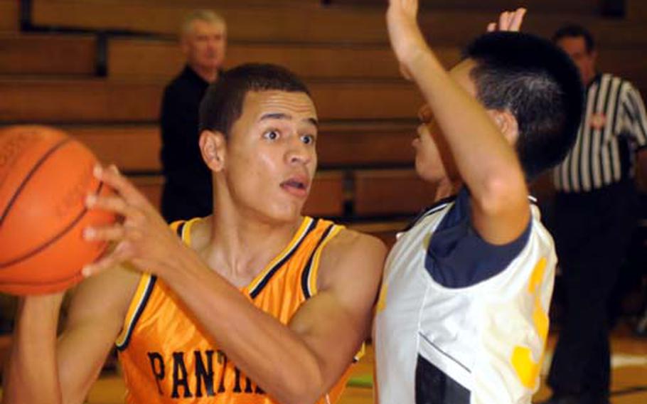 Kadena Panthers senior forward Jeremy Howell (40) looks to pass past a Koza defender during Friday&#39;s high school boys basketball season opener at Panther Pit, Kadena HIgh School, Kadena Air Base, Okinawa. Howell, a transfer from Brussells, Belgium, scored 21 points as Kadena routed Koza 92-58.