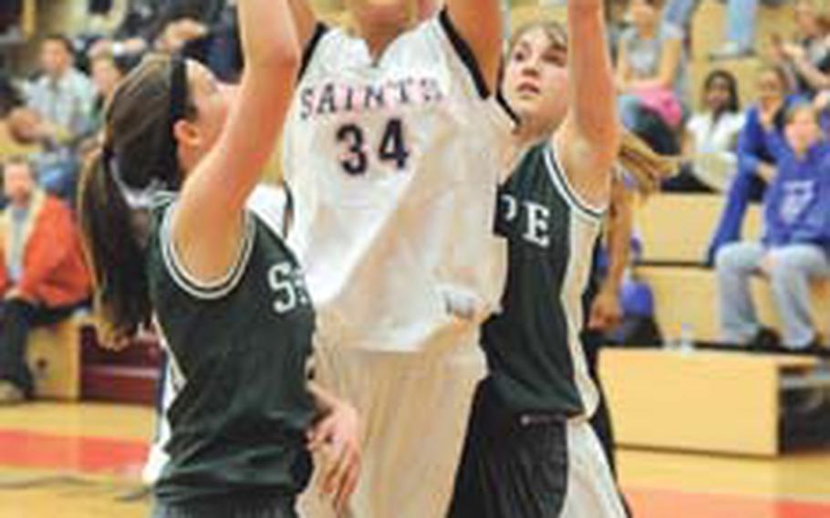 Aviano’s Jasmine Mailoto looks to the basket against the defense of SHAPE’s Tammy Northshield, left, and Samantha Saunders in last season’s Division II final that Aviano won in February. Mailoto and her Saints teammates will try to successfully defend their title, while the Spartans have moved up to Division I for the 2009-10 season.