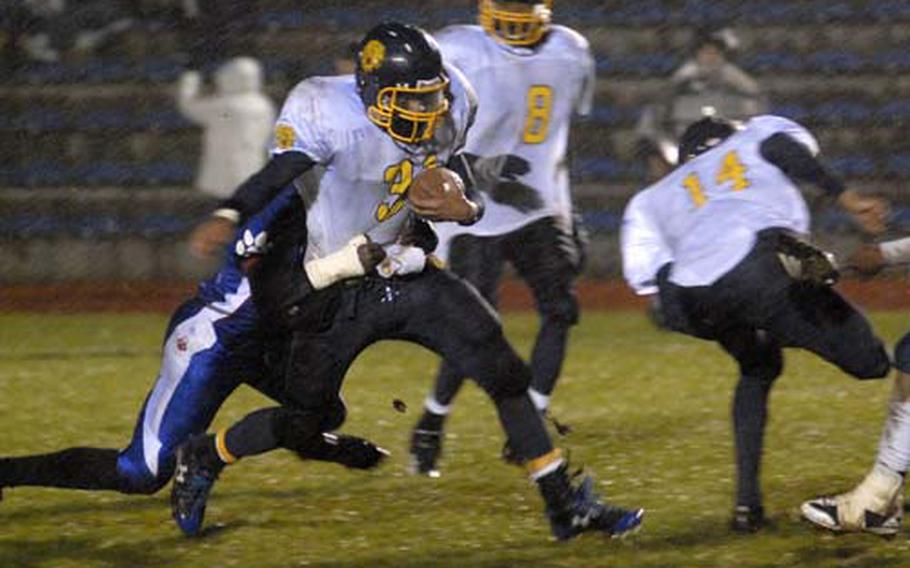 Thomas Hogue of Heidlelberg picks up yardage against Ramstein in the pouring rain Saturday during their Division I DODDS-Europe football championship at Baumholder. Hogue was named to the all-Europe football team at running back and linebacker.