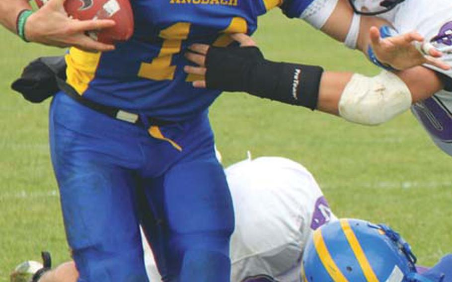 Ansbach quarterback Dominic Barrale fends off a Mannheim tackler and picks up yardage during Ansbach&#39;s 44-6 win Saturday. Barrale ran for one touchdown and a two-point conversion, and passed for two TDs and a two-point conversion as the Cougars advanced to the next round of the Division II playoffs.