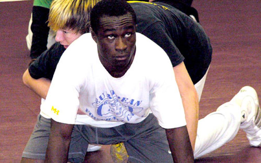 Baumholder junior Prince Owusu waits for the whistle before starting an escape drill with his teammate, Ethan Montang, top, the defending European 130-pound champion, during a Tuesday practice. Owusu, who is beginning just his second season in wrestling, finished fifth in Europe last season at 140.