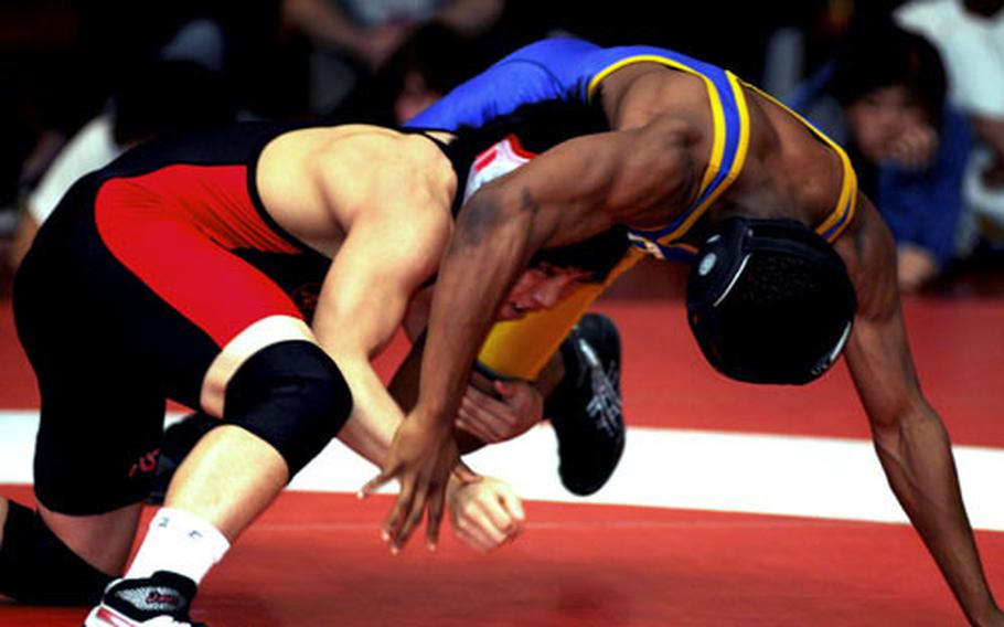 Elijah Gamble of Nile C. Kinnick tries to get the upper hand on Devin Day of Yokota during Saturday&#39;s 135-pound gold-medal bout. Gamble decisioned Day 2-0.