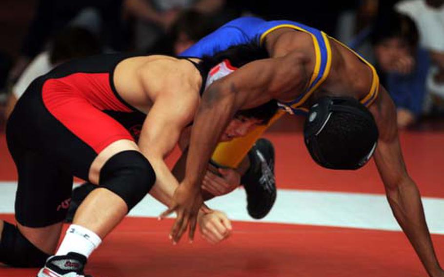 Kinnick’s Elijah Gamble, left, tries to get the upper hand on Yokota’s Devin Day during Saturday’s 135-pound final in the Nile C. Kinnick Invitational “Beast of the Far East” Wrestling Tournament at Yokosuka Naval Base, Japan. Gamble decisioned Day 2-0.