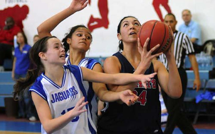 Sigonella&#39;s Andrienn Moore, left, and Mekayla Valentine try to keep Aviano&#39;s Jasmine Mailoto from getting of a shot in a game in Aviano on Saturday. Aviano won 55-13.