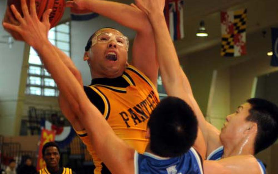 Kadena senior Kevin Paranal goes up for a shot against two Konan defenders during Sunday’s championship game in the 4th Okinawa-American Basketball Shootout at Foster Field House, Gunners Fitness & Sports Center, Camp Foster, Okinawa. Konan won 60-57.