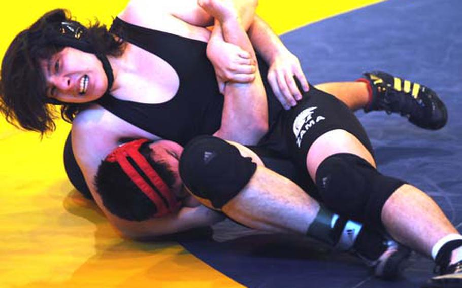 Ken Schulteis of Zama American secures Nile C. Kinnick&#39;s David de los Santos with a head-and-arm hold during Saturday&#39;s 215-pound bout in the 2010 Kanto Plain Association of Secondary Schools Wrestling Tournament at TitanDome, St. Mary&#39;s International School, Tokyo. De los Santos rallied to decision Schulteis 2-0 (3-0, 5-4) and Kinnick went on to win the team title with 87 points, six gold medals and two each silver and bronze.