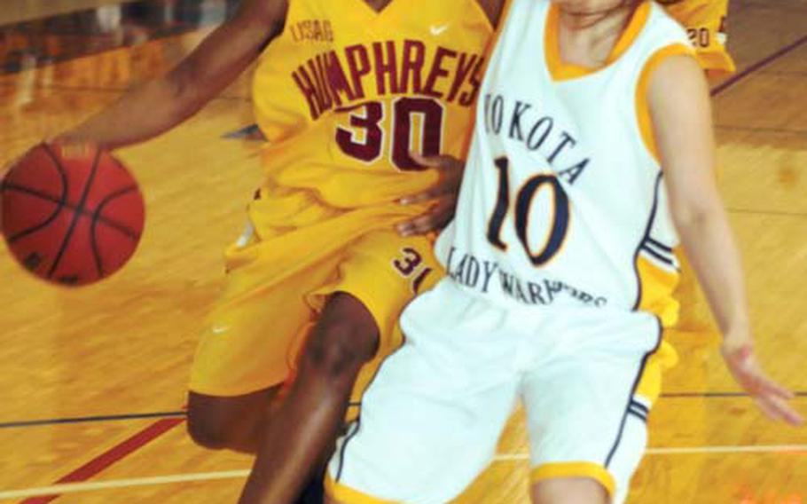 Keisha Harper of Camp Humphreys dribbles against Nayu Takahashi of Yokota Air Base during Sunday’s women’s championship game of the March Madness Pacific Regional Basketball Tournament.